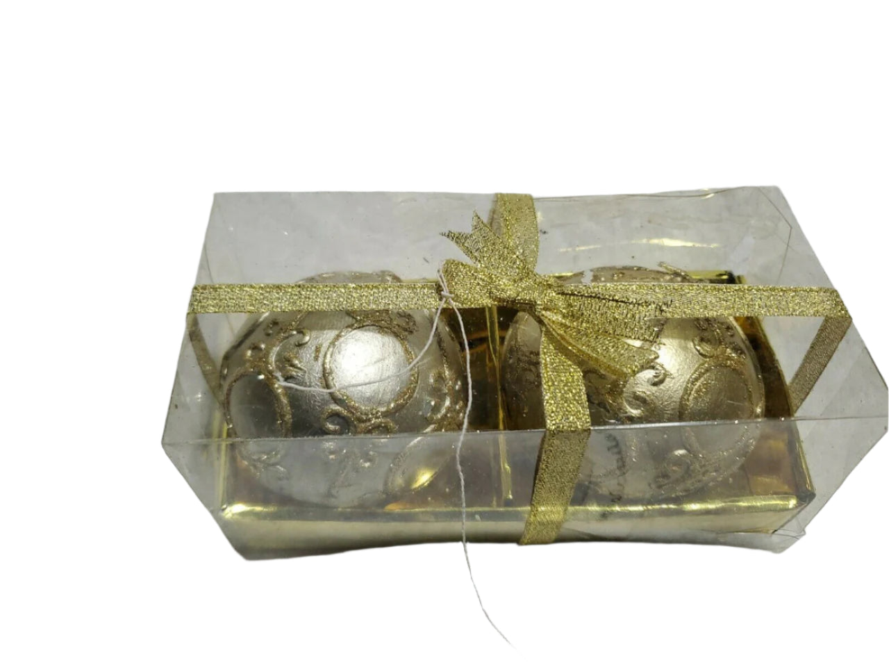 Set of two round ball candles in gold and silver by Laila Rowe, packaged in a clear gift box with gold ribbon.