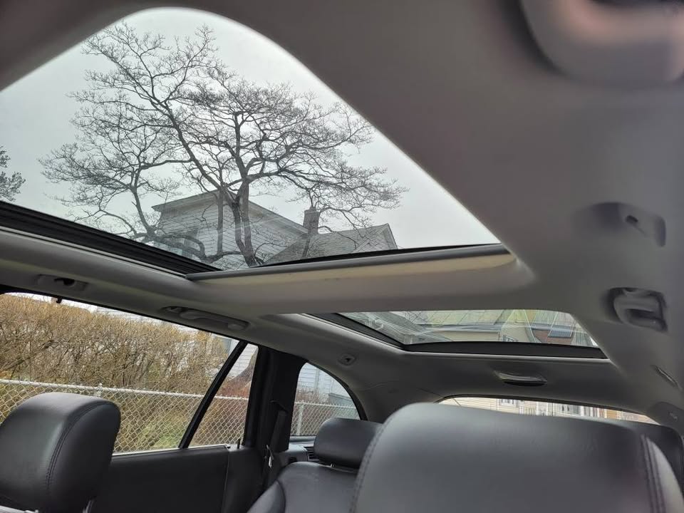 Interior view of 2009 Mercedes-Benz R350 showing open panoramic sunroof and rear leather seats with natural light