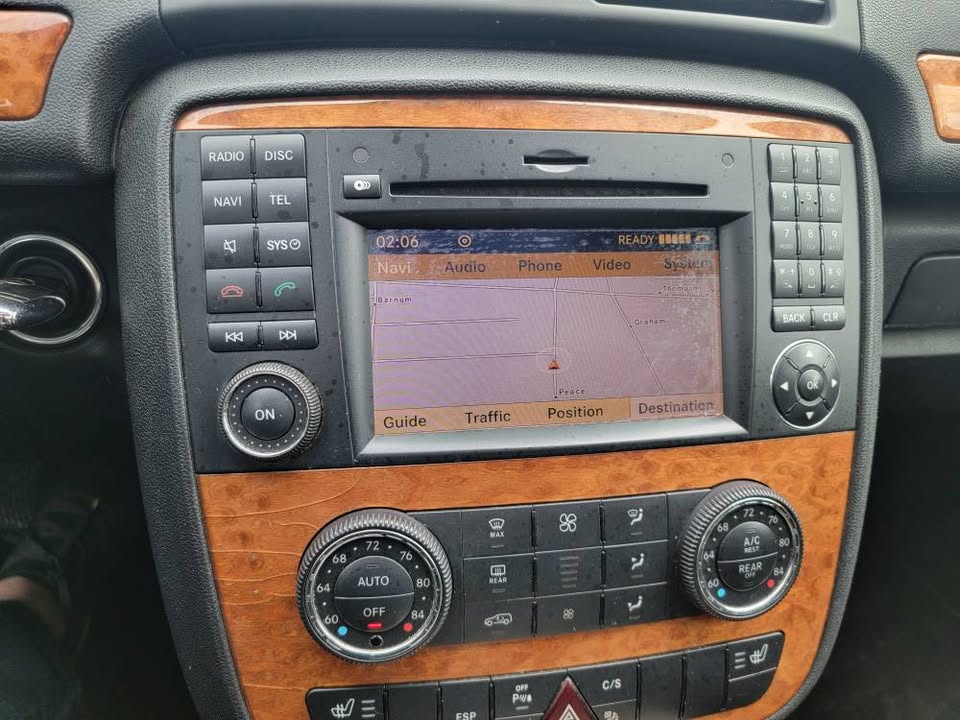Navigation screen and wood-trimmed center console of 2009 Mercedes-Benz R350 showing GPS map and climate control panel