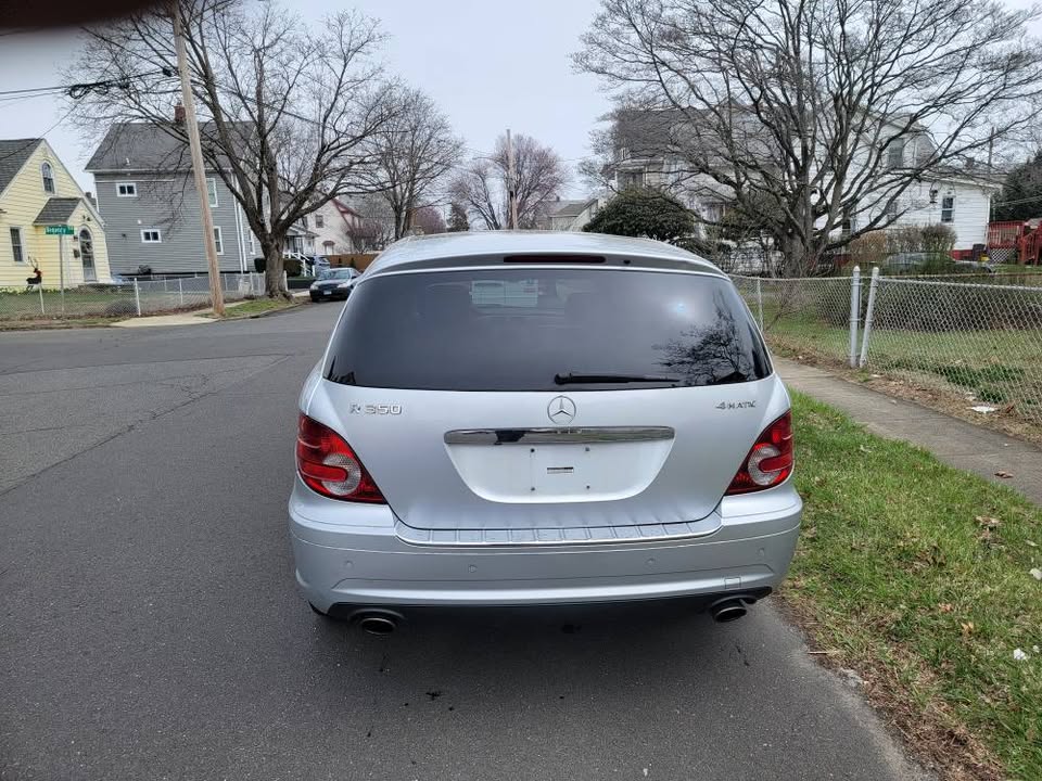 Rear view of silver 2009 Mercedes-Benz R350 AWD parked on residential street, showing tinted rear window and dual exhaust