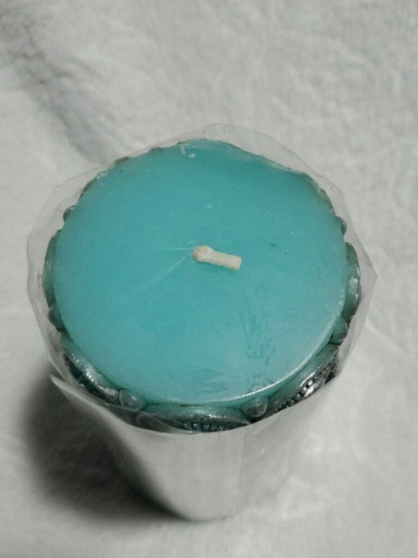 Blue 6" pillar candle with raised ornamental texture, unscented and cylindrical in shape, ideal for decor.