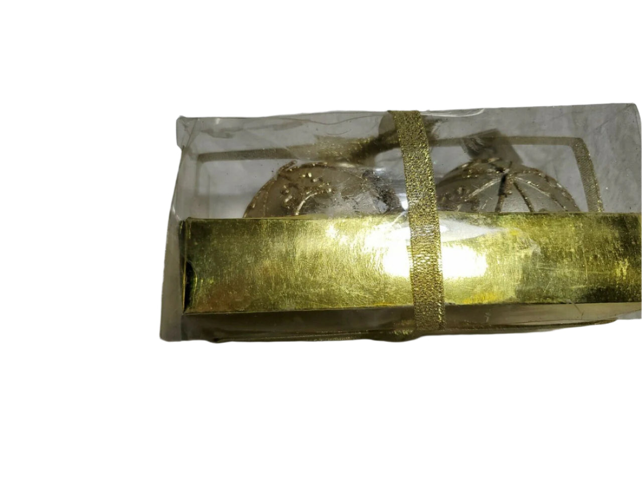 Set of two round ball candles in gold and silver by Laila Rowe, packaged in a clear gift box with gold ribbon.