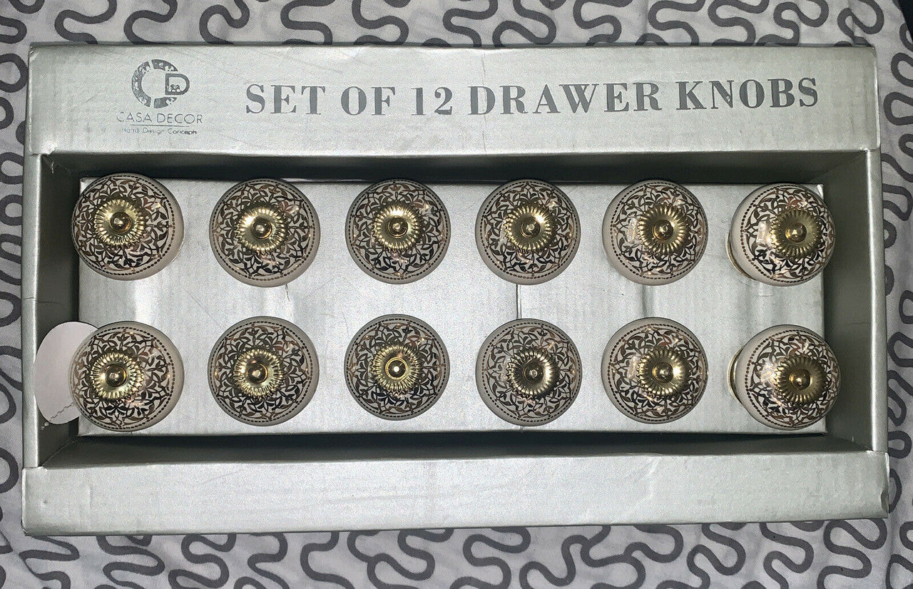 A set of 12 silver ceramic drawer pulls with intricate designs, packaged in a box.