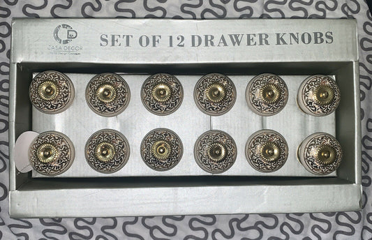 A set of 12 silver ceramic drawer pulls with intricate designs, packaged in a box.