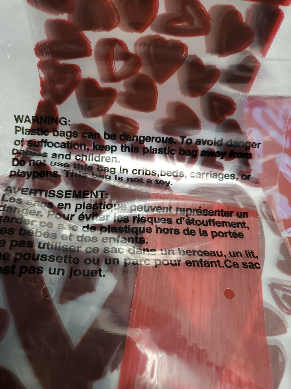 Close-up of a plastic bag with heart-shaped objects and warning labels.