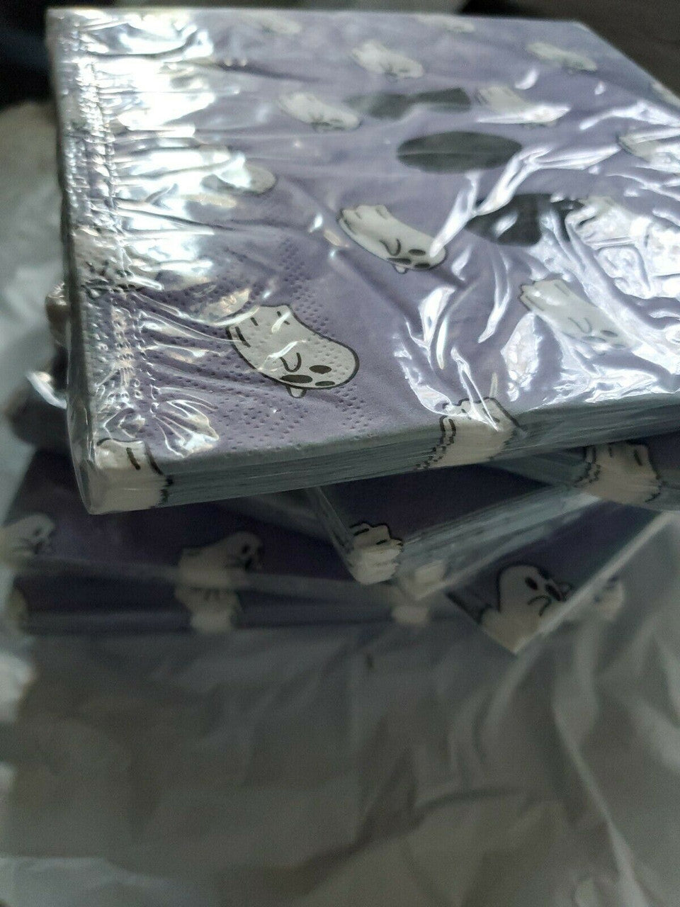 Stack of purple Halloween paper napkins with white ghost and BOO design in packaging