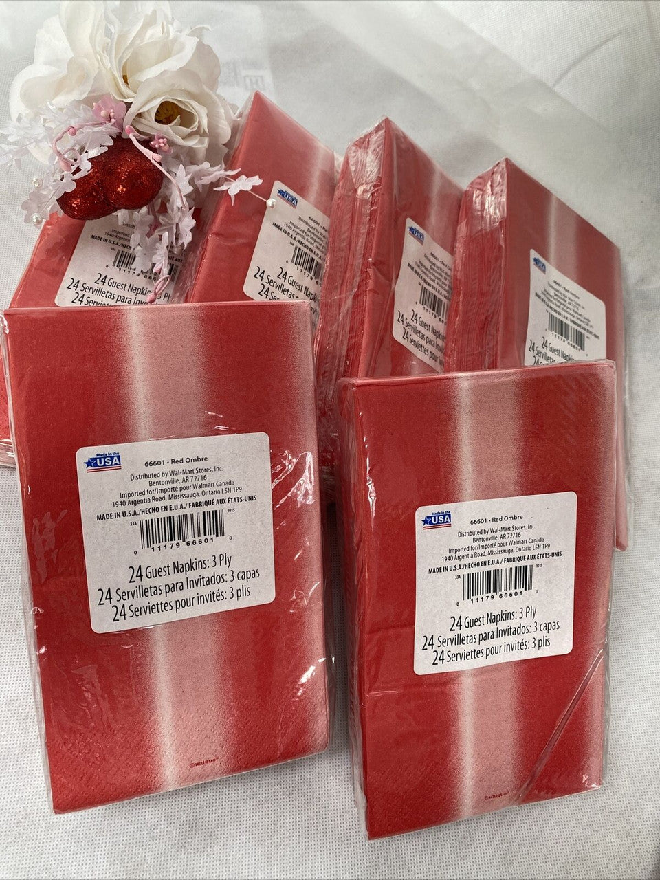 Six packs of red ombre paper guest napkins wrapped in packaging, 3-ply disposable napkins by Diva made in the USA