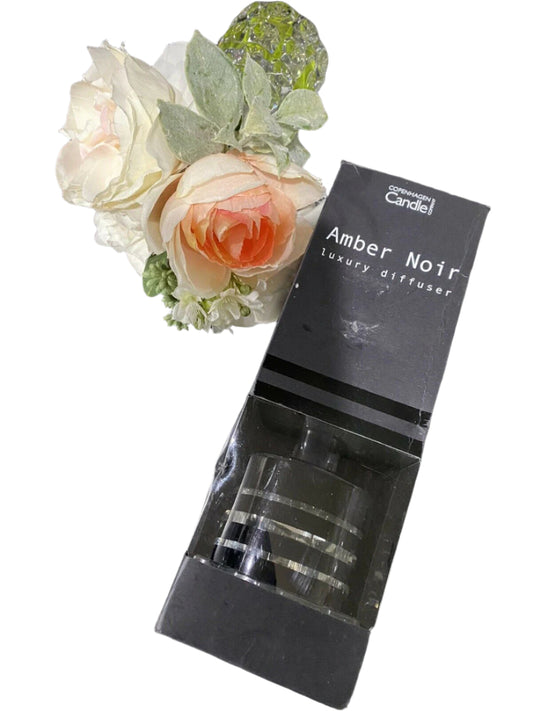 Amber Noir reed diffuser by Copenhagen Candle Company in black gift box with floral backdrop – 100mL size, modern home scent