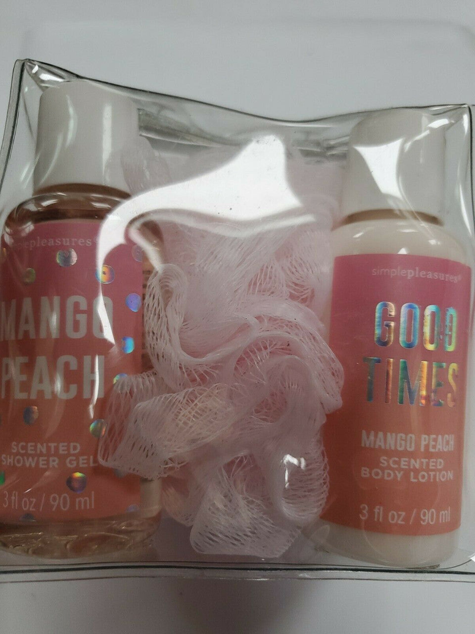 A clear plastic packaging containing two bottles of scented shower gel and body lotion with a pink label, a shaker, and a spray bottle, all with 'Mango Peach' scent branding.