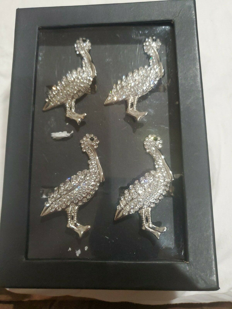 Set of four silver rhinestone turkey napkin rings displayed in black gift box