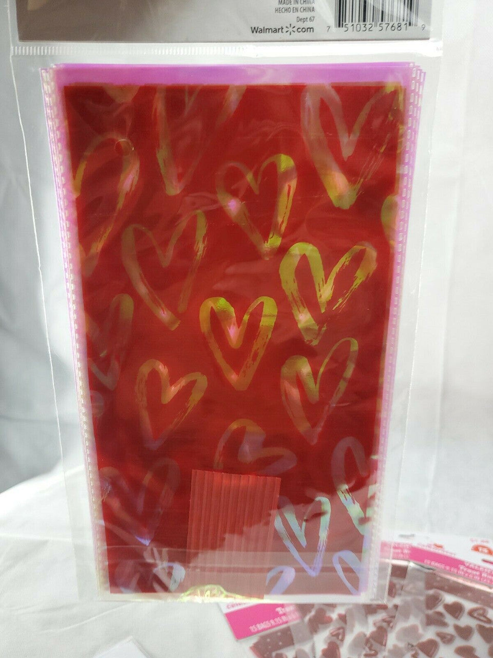 Six packs of Valentine’s Day treat bags in red with multi-colored hearts, mixed counts of ten and fifteen bags per pack.
