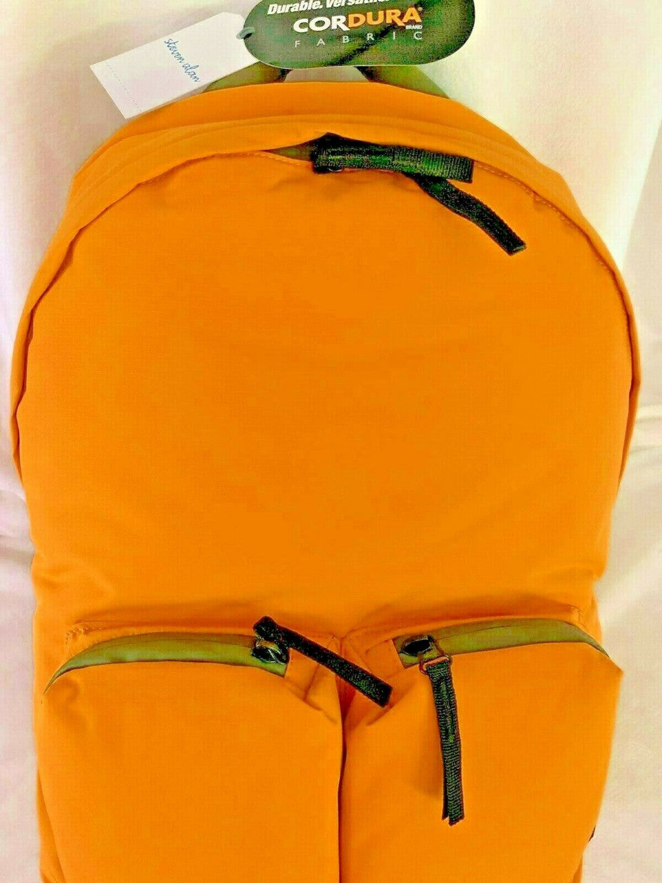Orange backpack with green zippers on a white background.