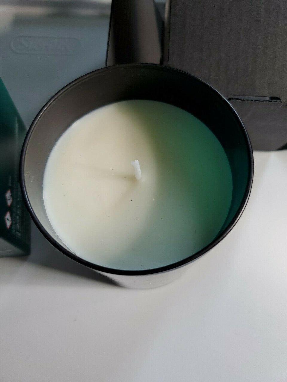 Crabtree & Evelyn Raw Instinct scented candle in green glass jar with copper lid, 8.8 oz premium soy wax blend.