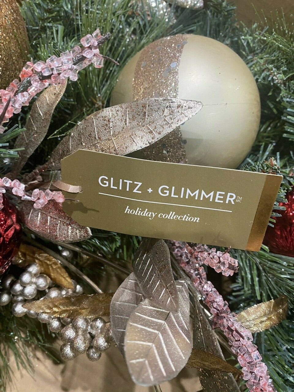 Decorative ornament with gold and silver details on a Christmas tree.