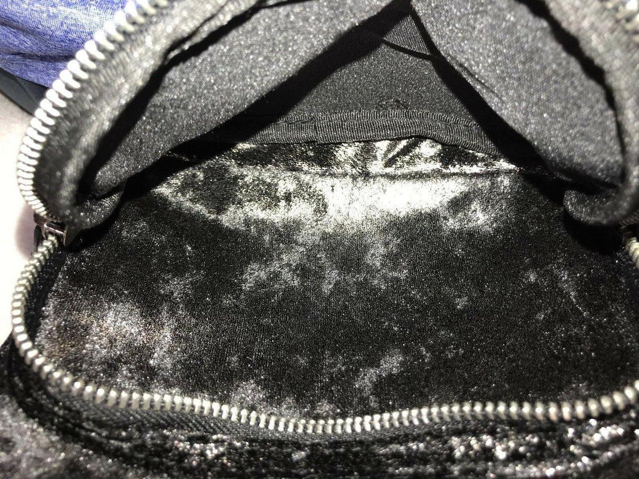 Black faux fur mini backpack with silver tint and front zip pocket with metallic studs