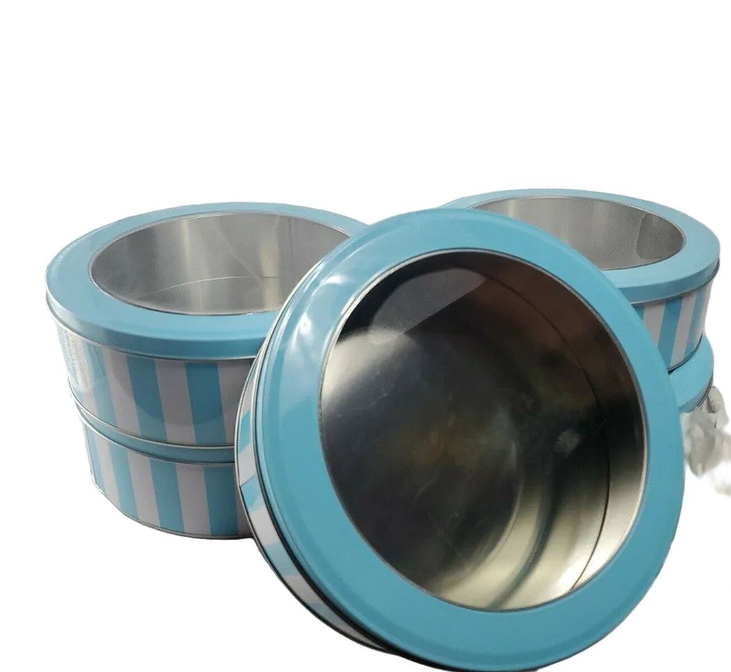 A set of five round window tins with blue and white stripes, 8 inches in diameter and 3 inches high, displayed alongside some decorative elements.