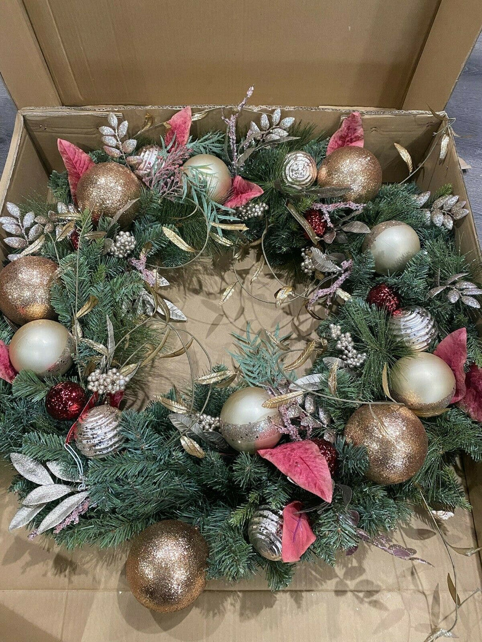 Decorative Christmas wreath with ornaments in a box.