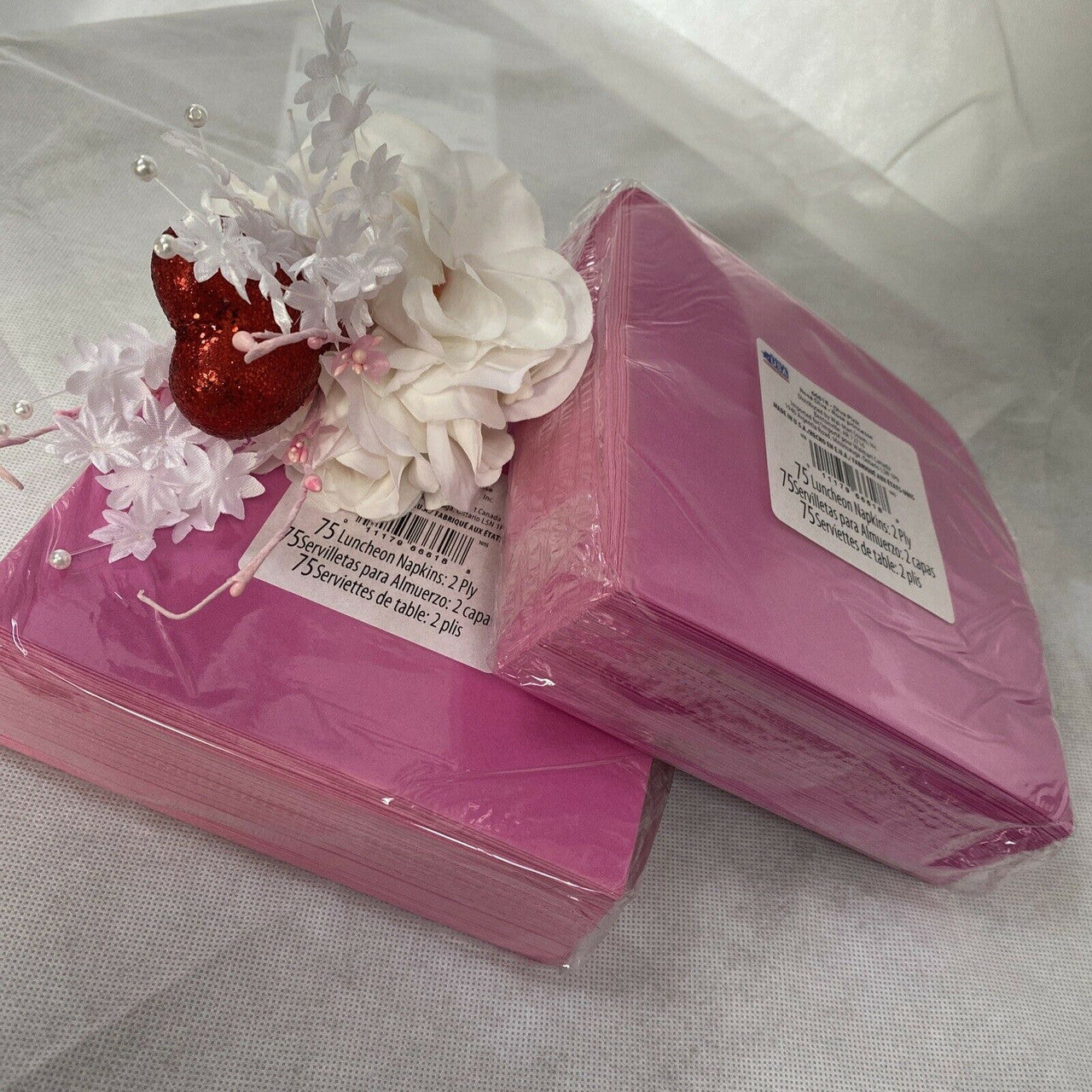 Two packs of pink paper luncheon napkins stacked in packaging, Diva Pink Princess 2-ply disposable napkins made in the USA