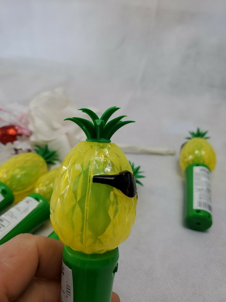Set of five handheld pineapple-shaped light-up spinner toys, battery operated.