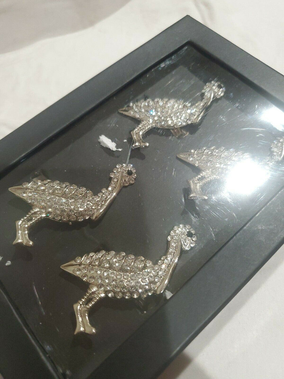 Set of four silver rhinestone turkey napkin rings displayed in black gift box