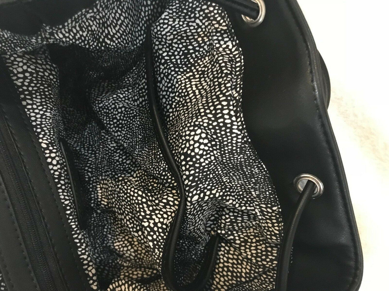 Steve Madden medium black faux fur backpack with decorative pin, side pockets, and drawstring flap