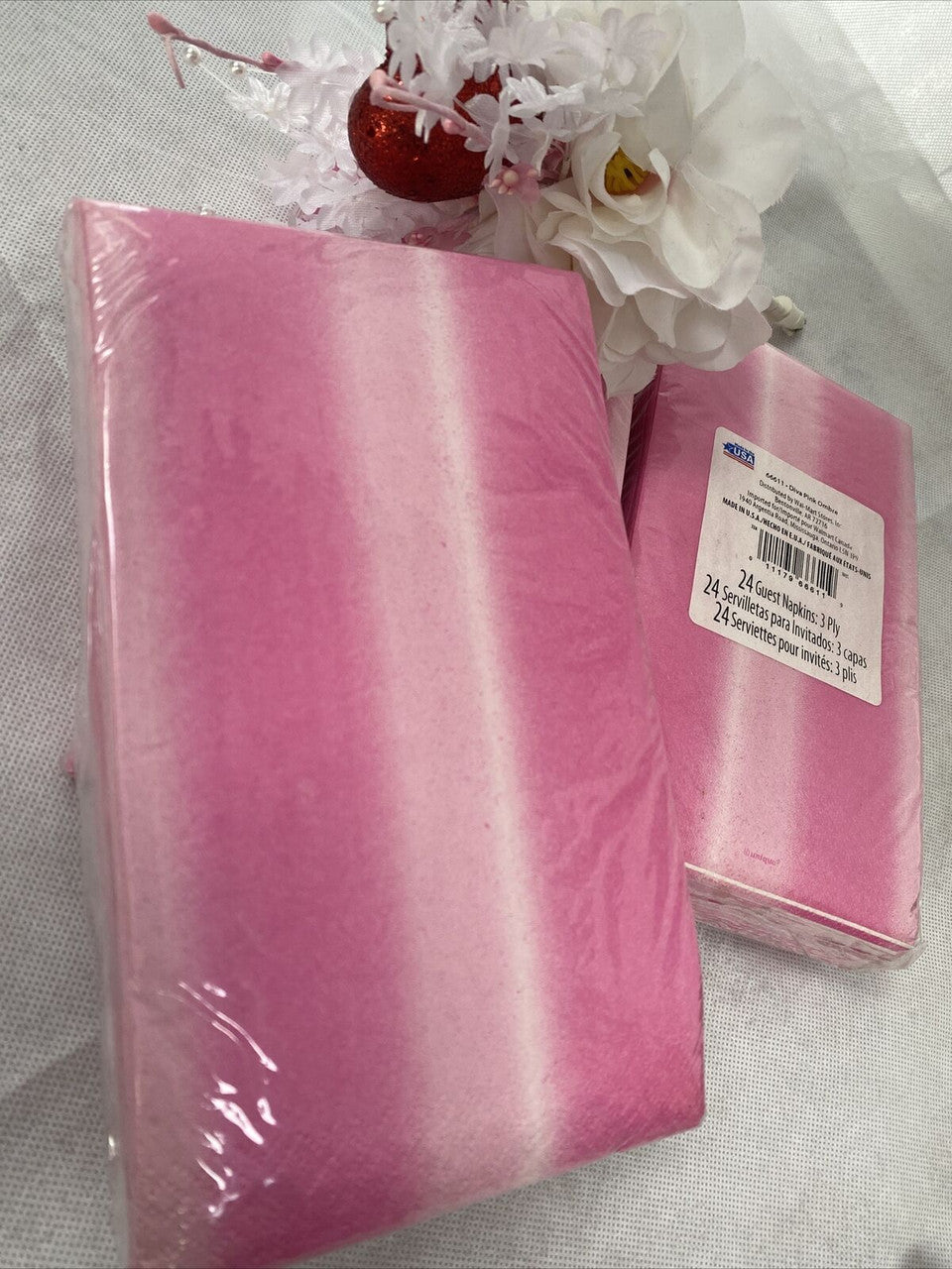 Three packs of pink ombre paper guest napkins wrapped in packaging, 3-ply disposable napkins by Diva made in the USA