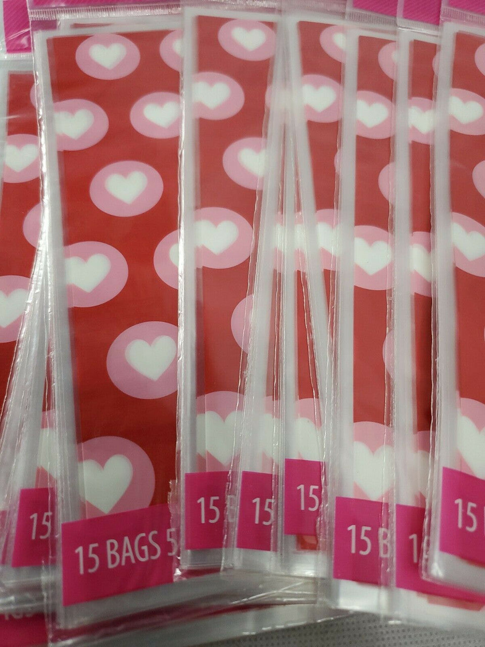 Red Valentine’s Day treat bags with white hearts, twelve retail packs with fifteen bags each and matching twist ties.