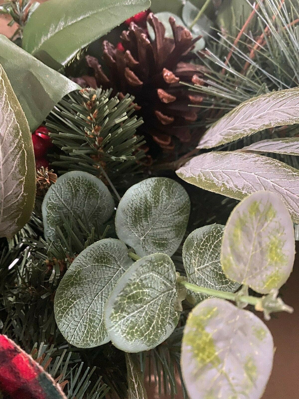 Close-up of green leaves and pinecones in a festive setting