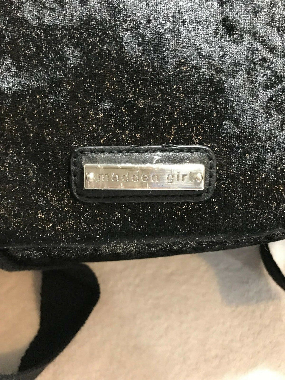 Black faux fur mini backpack with silver tint and front zip pocket with metallic studs