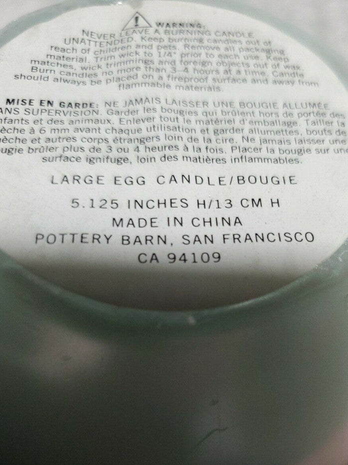 Light blue wax candle in an egg shape, 5.2 inches tall, sealed in clear plastic – Pottery Barn decorative piece.