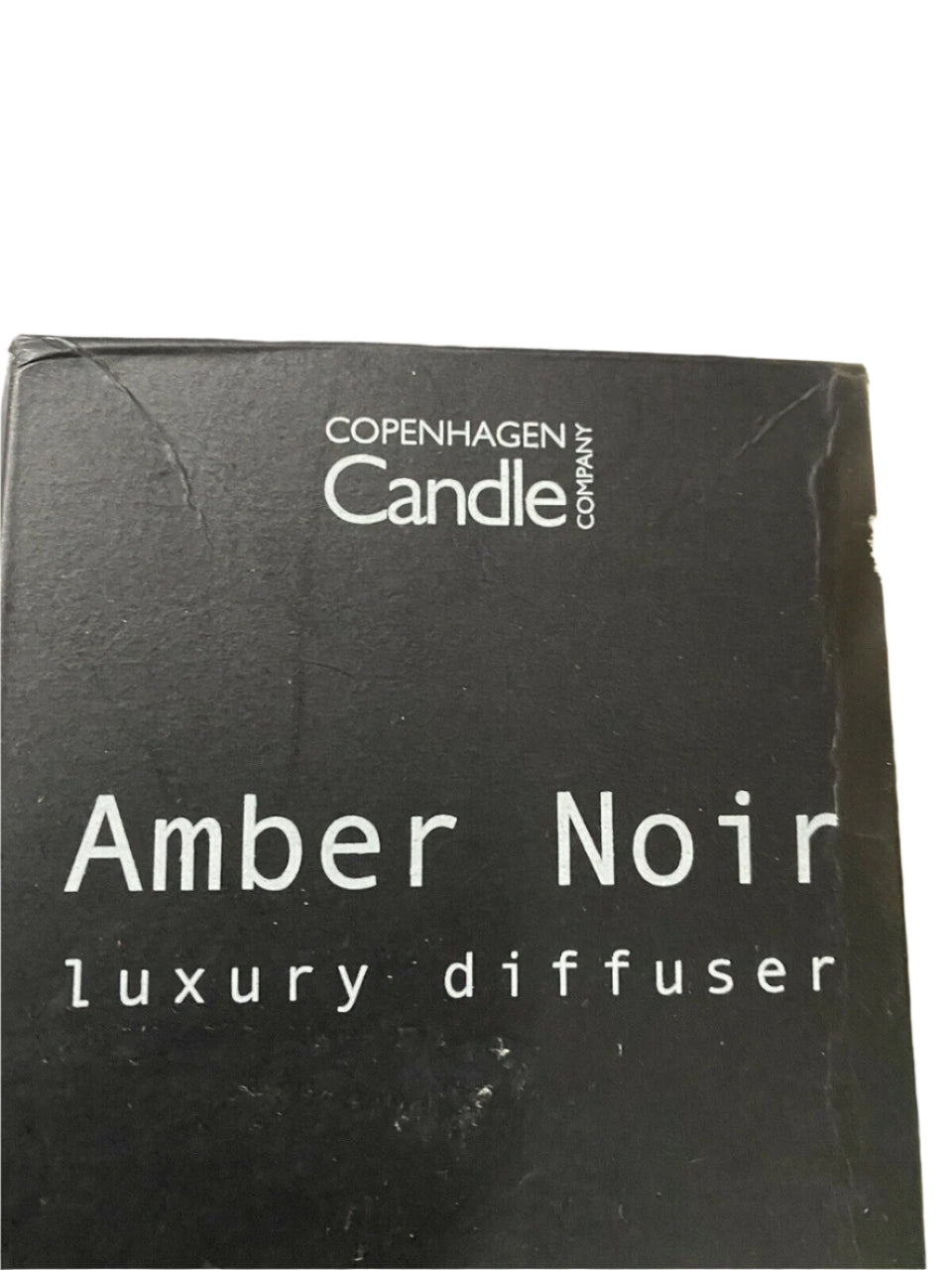 Amber Noir reed diffuser by Copenhagen Candle Company in black gift box with floral backdrop – 100mL size, modern home scent