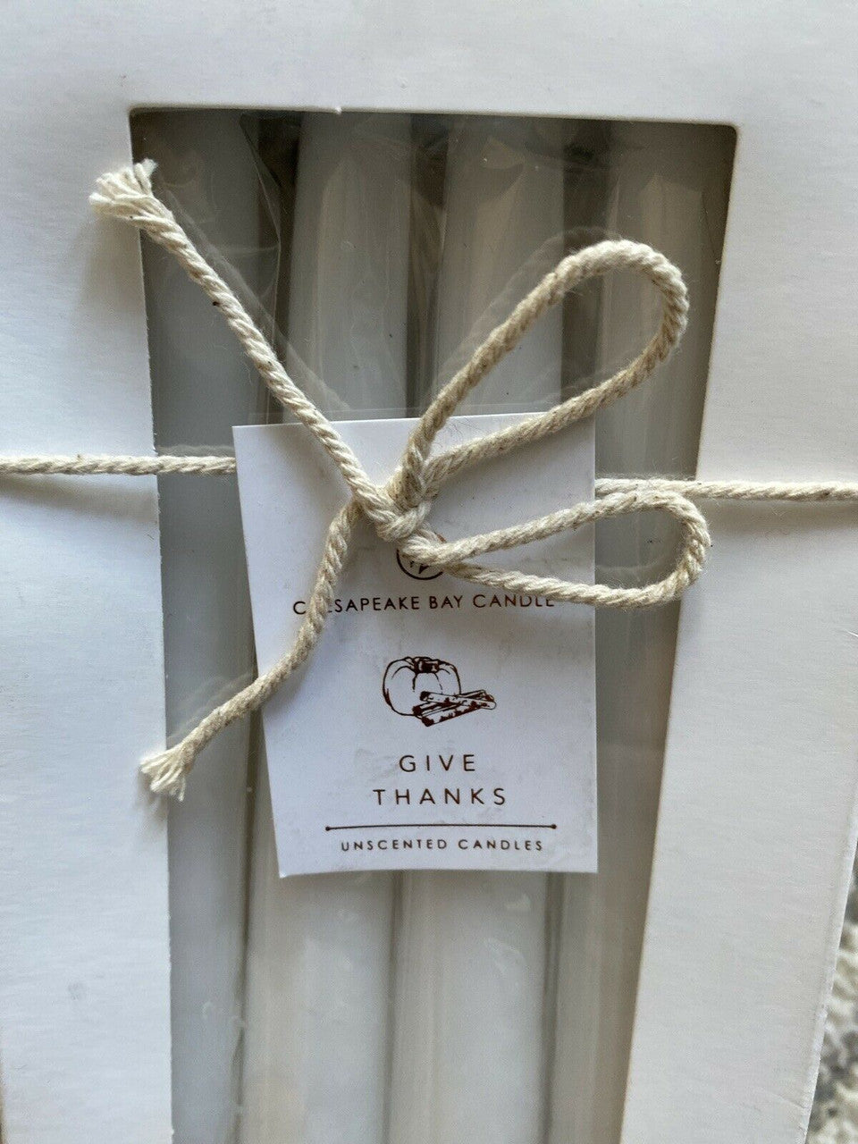 Set of 8 dripless unscented white taper candles in original packaging, ideal for elegant home decor or events