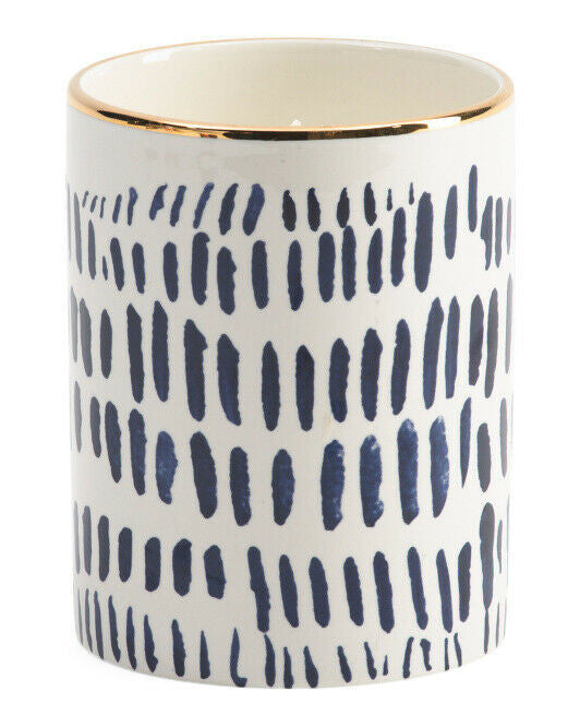 ILLUME 15oz Cardamom Clove Candle in decorative ceramic jar with navy brushstroke design and gold rim.