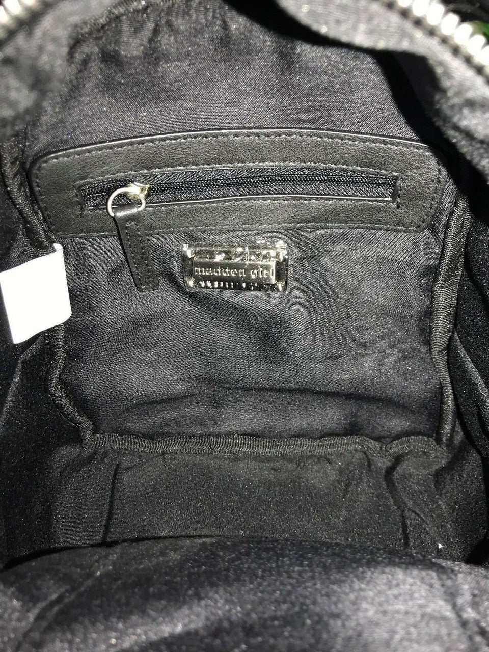 Black faux fur mini backpack with silver tint and front zip pocket with metallic studs