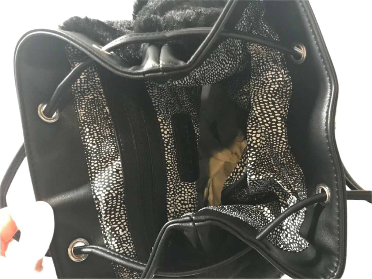 Steve Madden medium black faux fur backpack with decorative pin, side pockets, and drawstring flap
