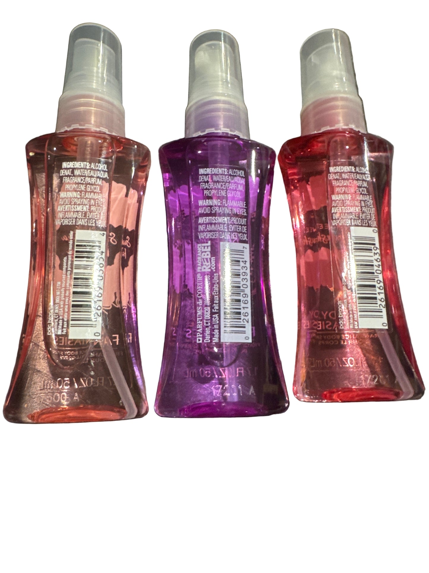 Three spray bottles with labels on a dark textured surface