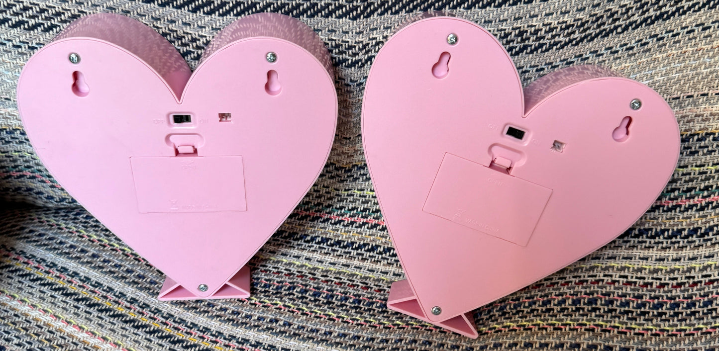 Two pink heart-shaped objects on a textured fabric background