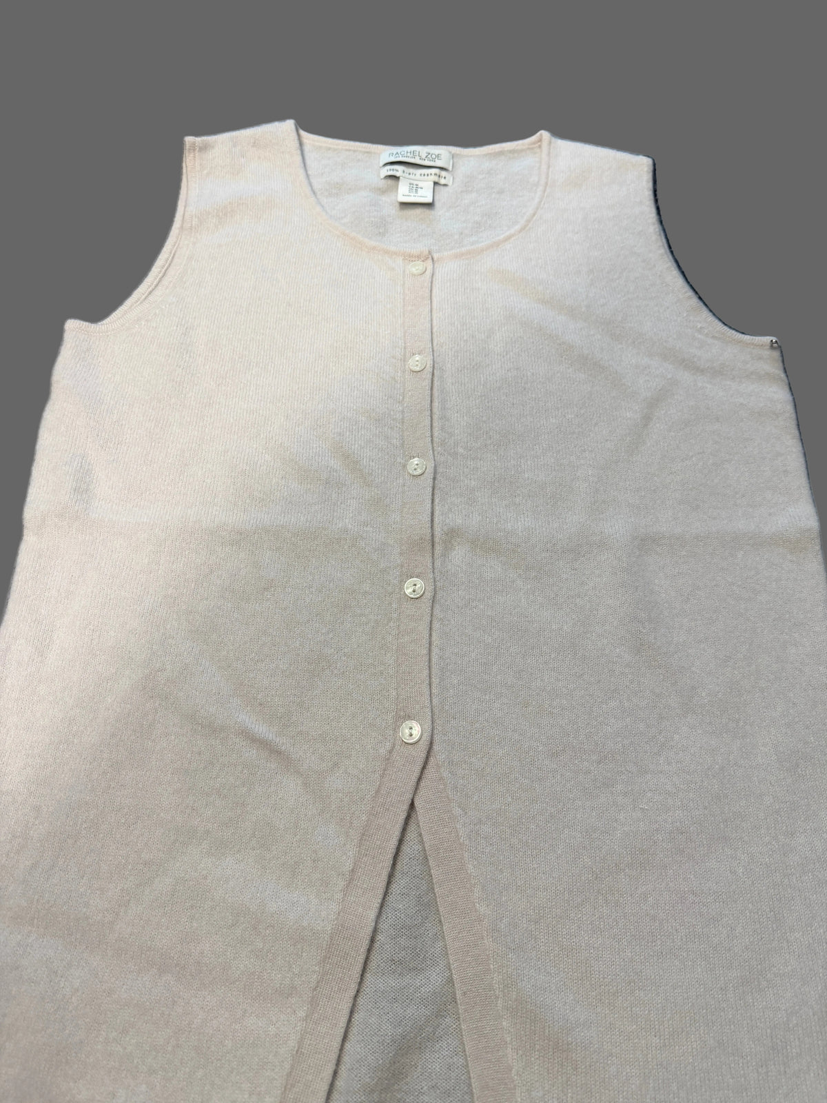 A light beige sleeveless knit top with a button-down front.