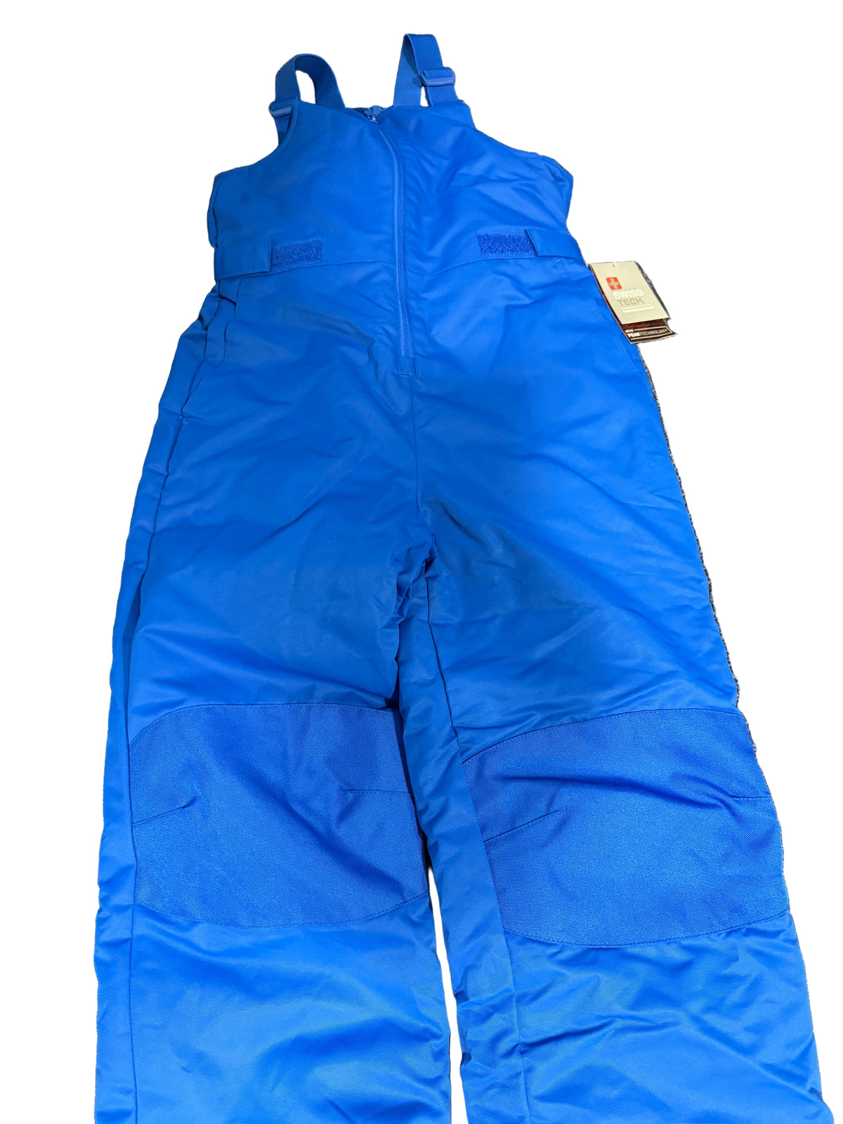 bright blue snow bib overalls laid flat , featuring a front zipper, shoulder straps, and a small paper tag attached near the upper right side.