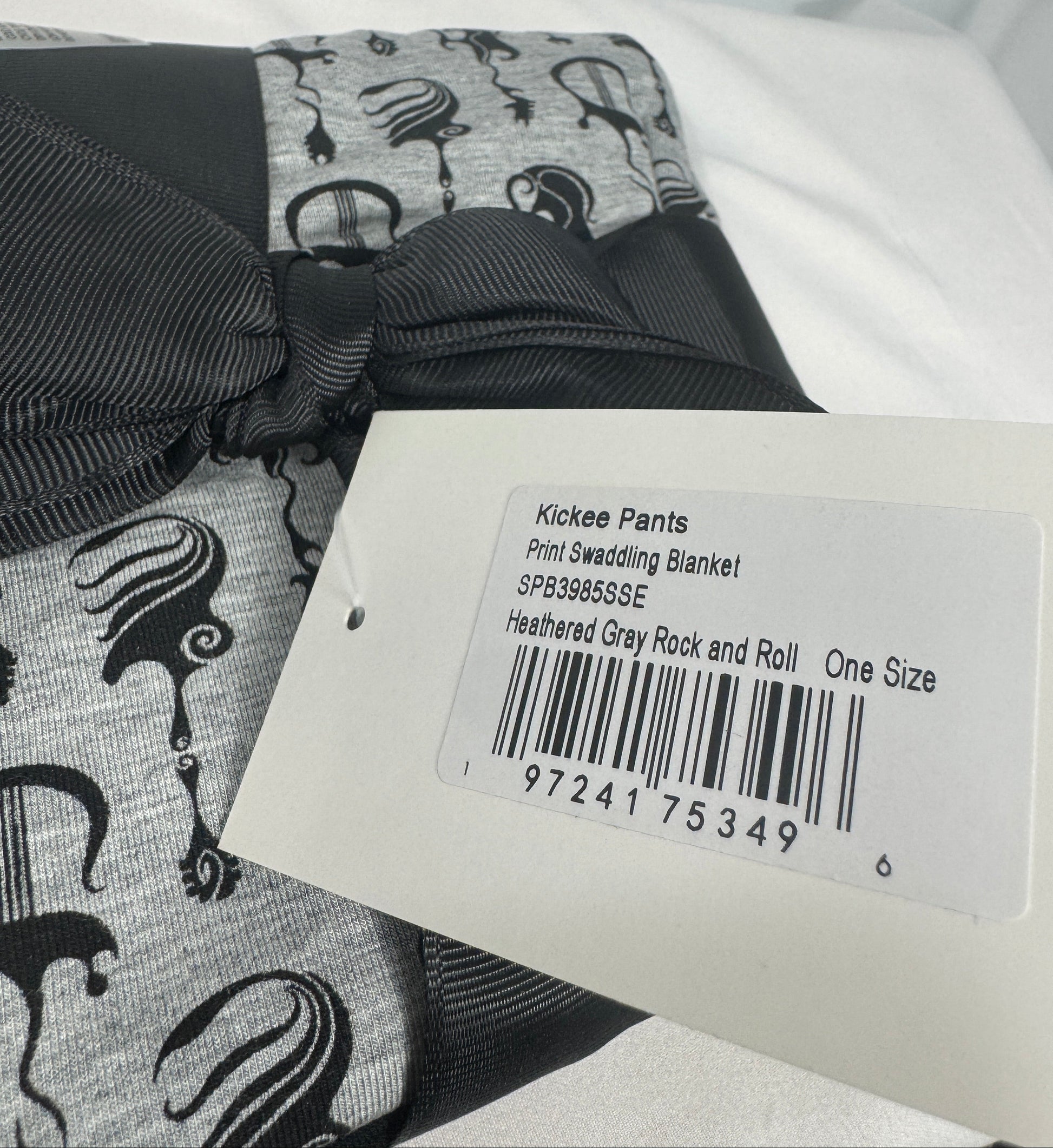 Clothing with a label showing product details on a light gray background