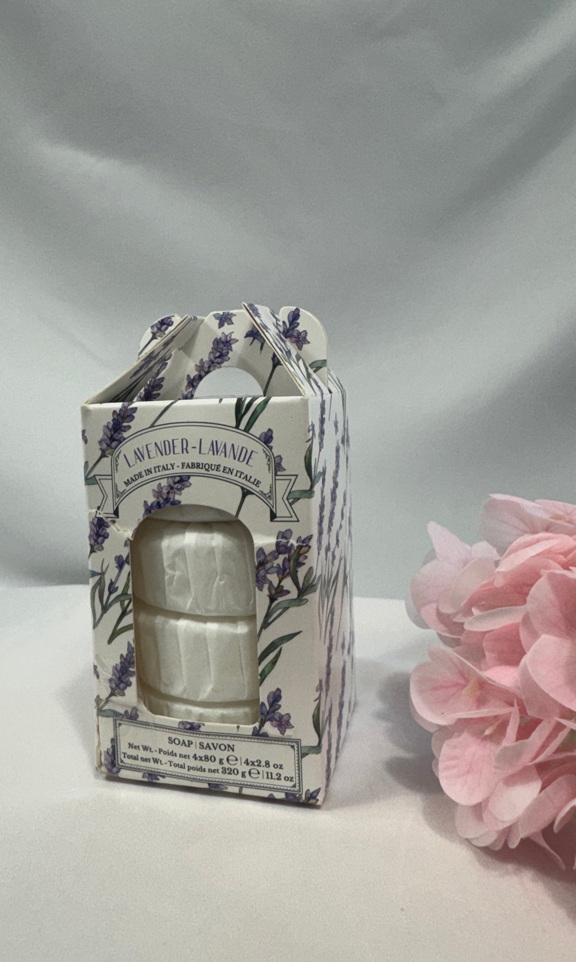 Bar of soap in a decorative box with floral design on a white background