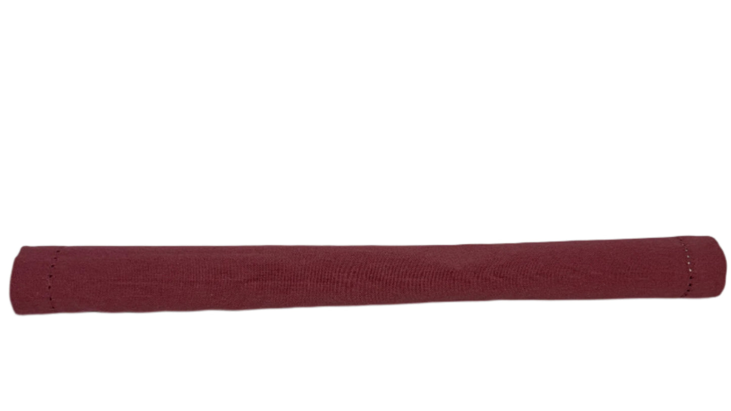 Rolled cotton napkin in a deep burgundy color, featuring neatly stitched edges