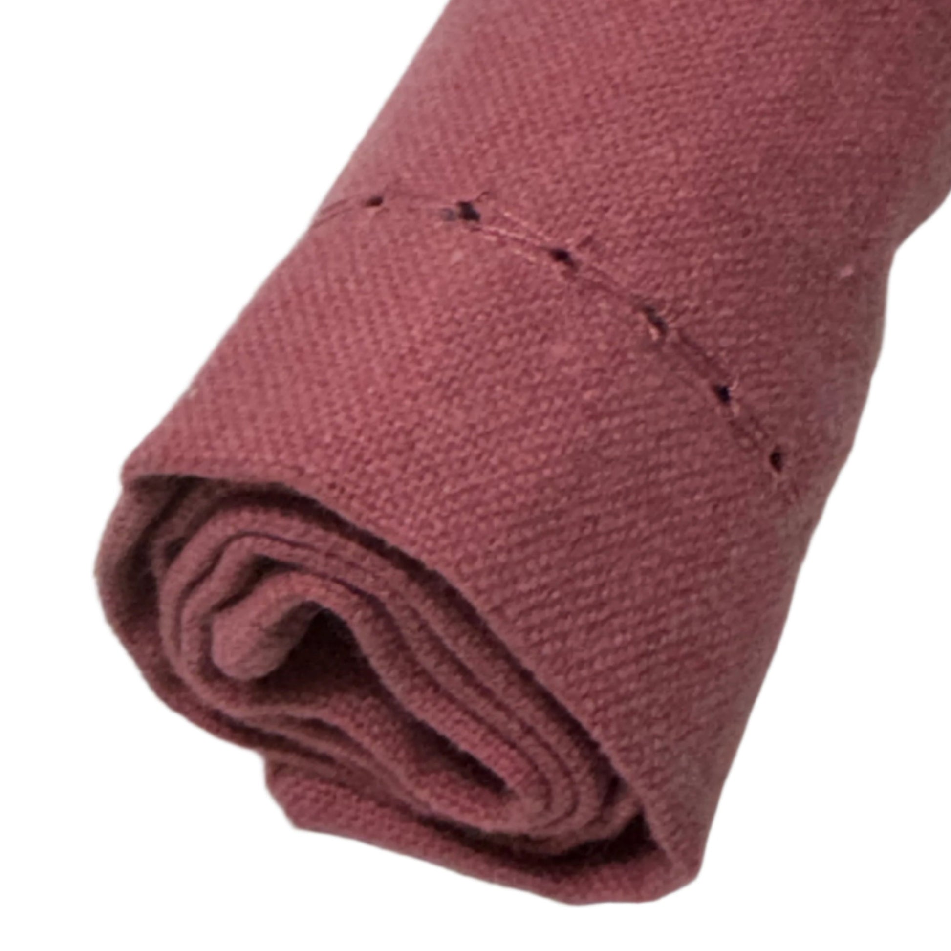 A single cotton napkin, neatly rolled with visible stitching along the edge, showcasing a soft burgundy color