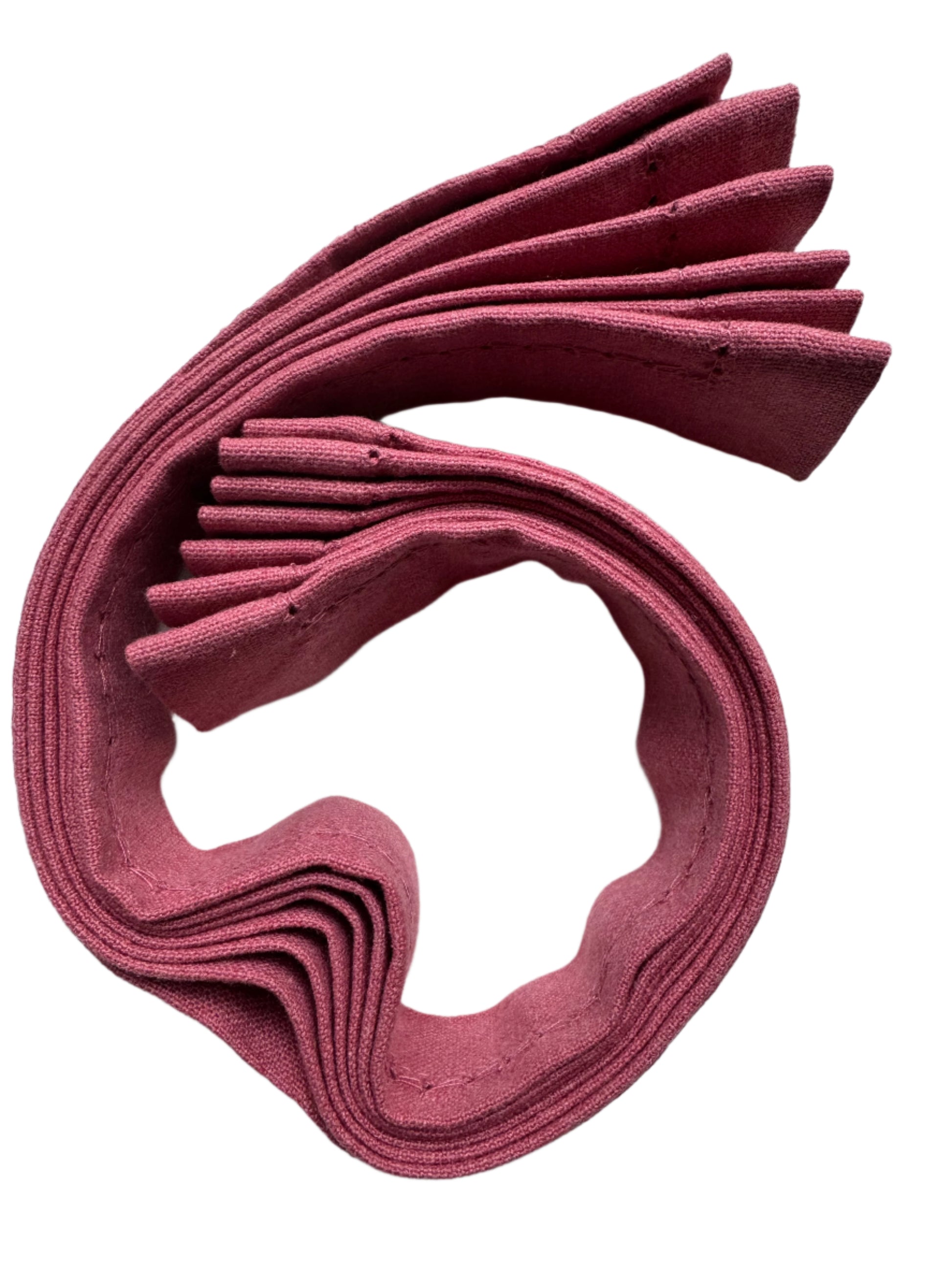 A rolled bundle of neatly stacked cotton napkins in a soft burgundy color, with visible fine stitching along the edges, showcasing a clean, organized presentation