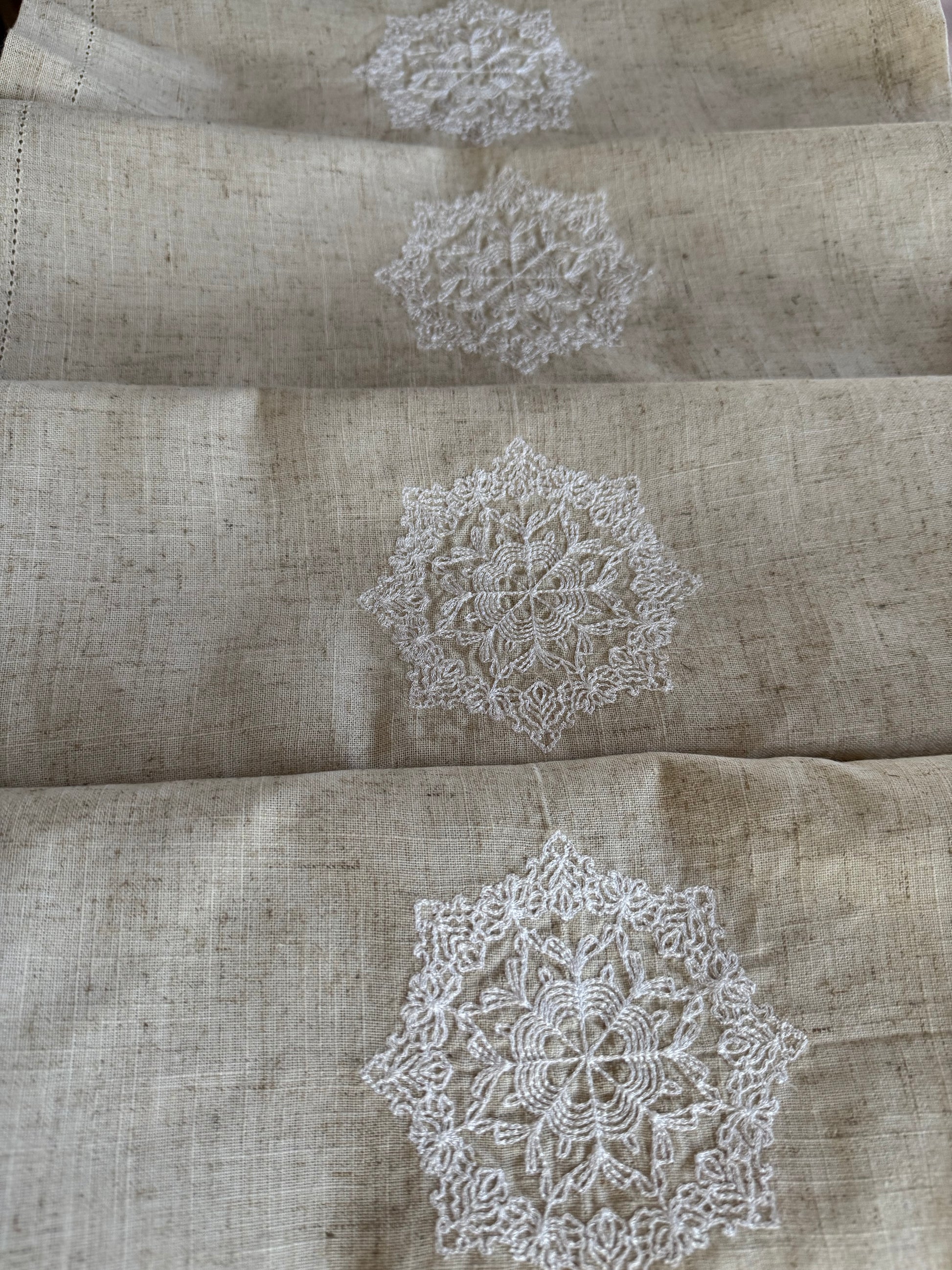 Natural beige linen dinner napkin with delicate embroidered detail and hemstitched edges, 17 x 17 inch reusable cloth napkin styled on an elegant table setting