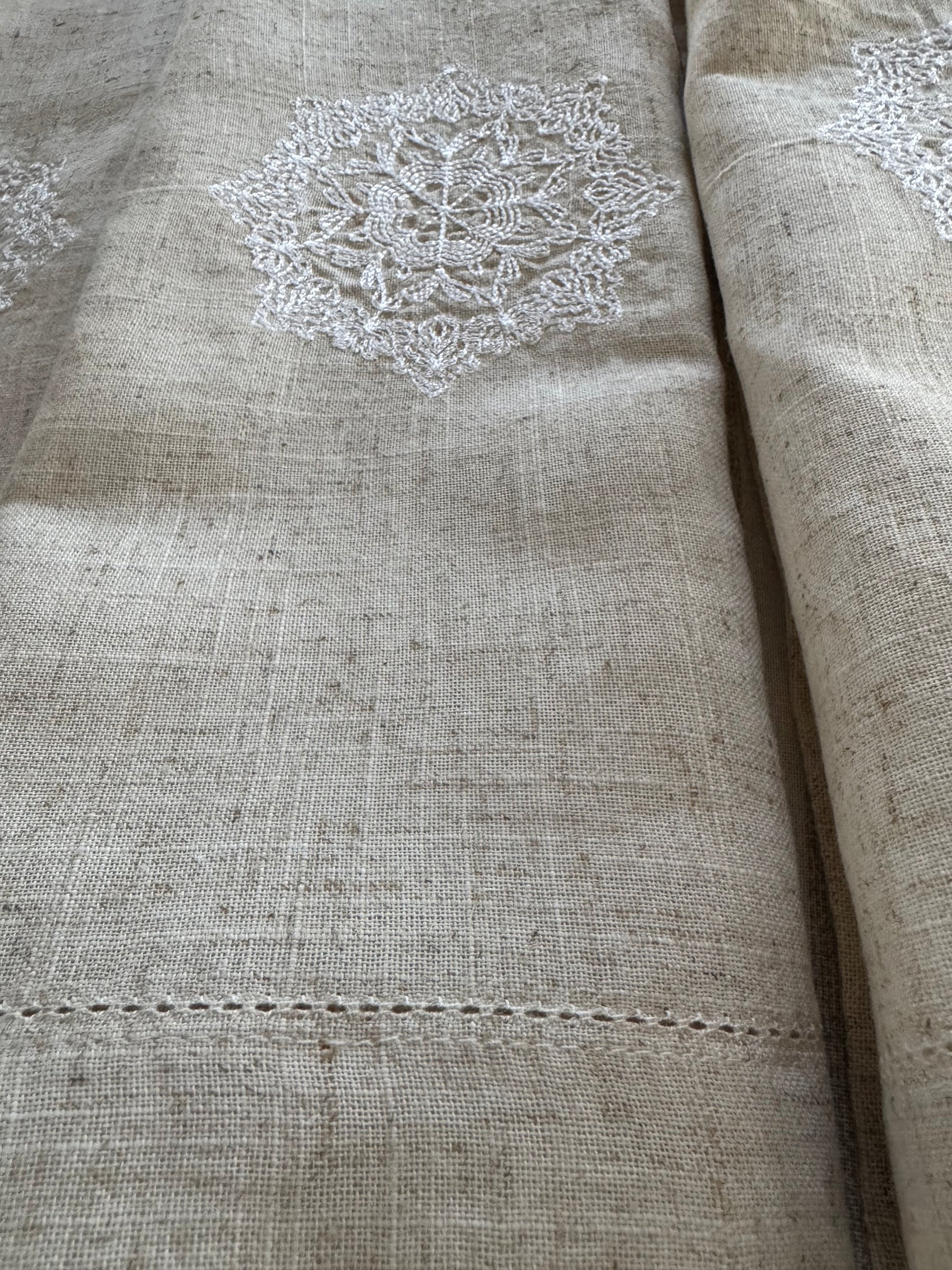 Natural beige linen dinner napkin with delicate embroidered detail and hemstitched edges, 17 x 17 inch reusable cloth napkin styled on an elegant table setting