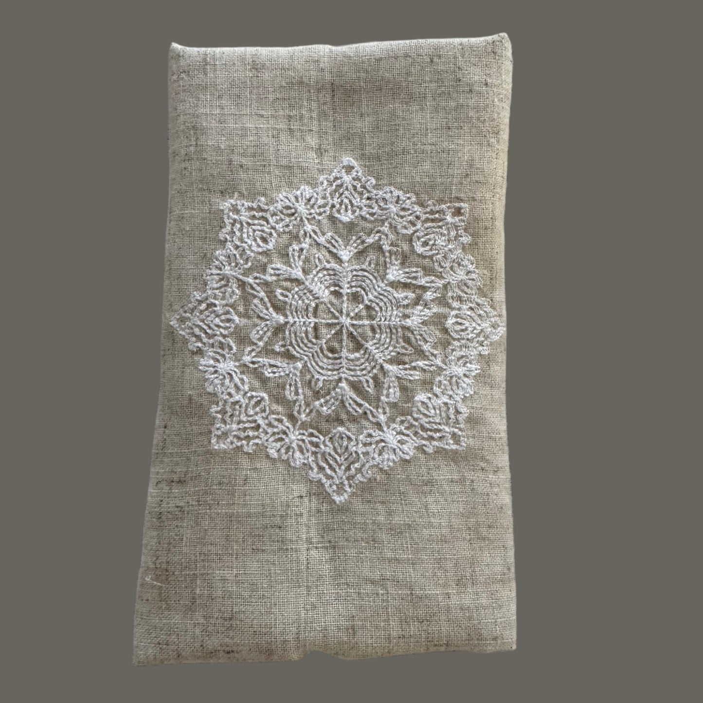 Natural beige linen dinner napkin with delicate embroidered detail and hemstitched edges, 17 x 17 inch reusable cloth napkin styled on an elegant table setting