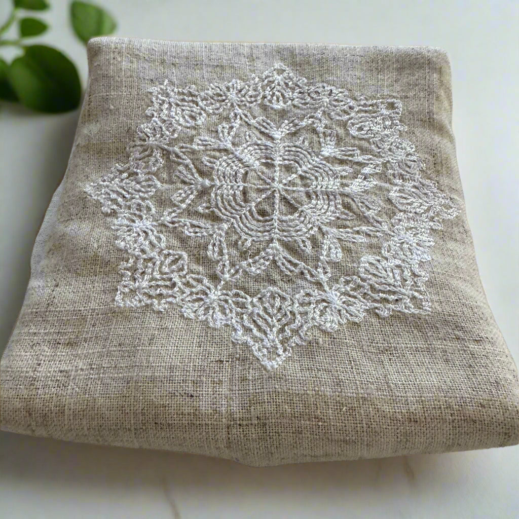 Natural beige linen dinner napkin with delicate embroidered detail and hemstitched edges, 17 x 17 inch reusable cloth napkin styled on an elegant table setting