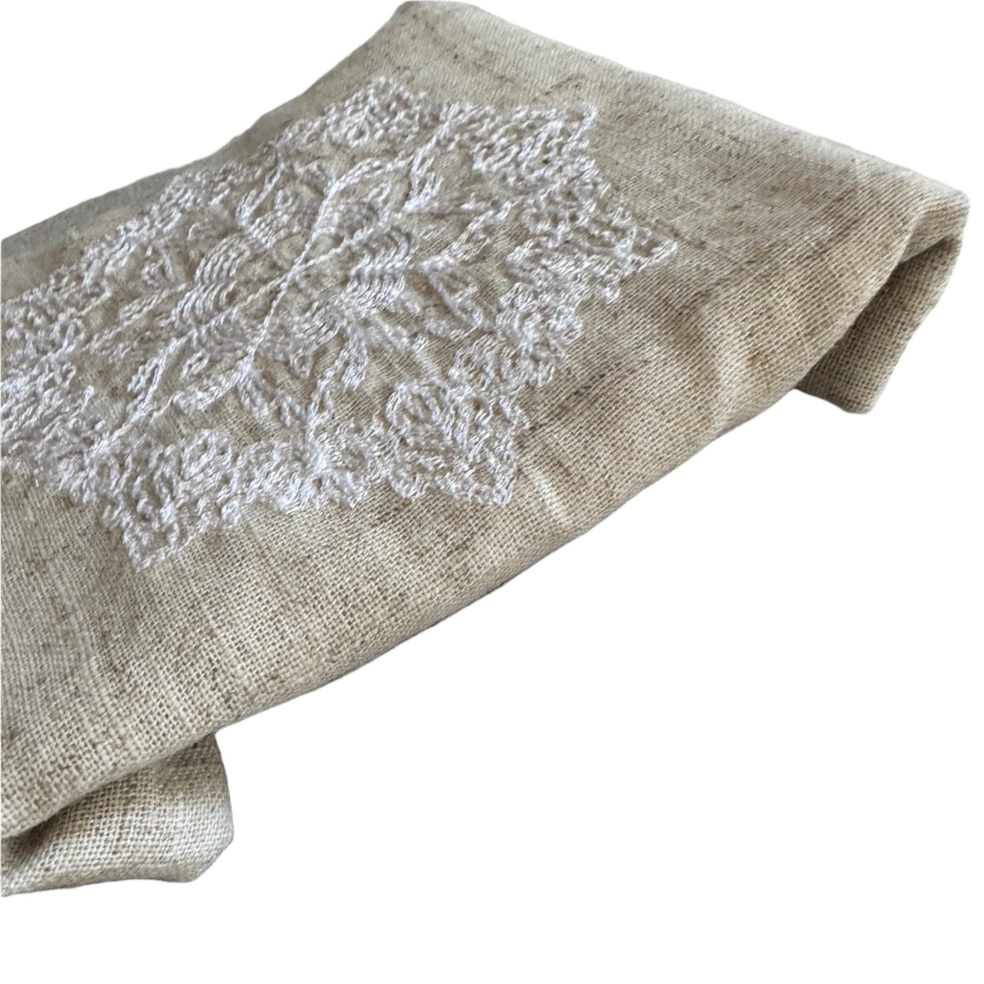 Natural beige linen dinner napkin with delicate embroidered detail and hemstitched edges, 17 x 17 inch reusable cloth napkin styled on an elegant table setting