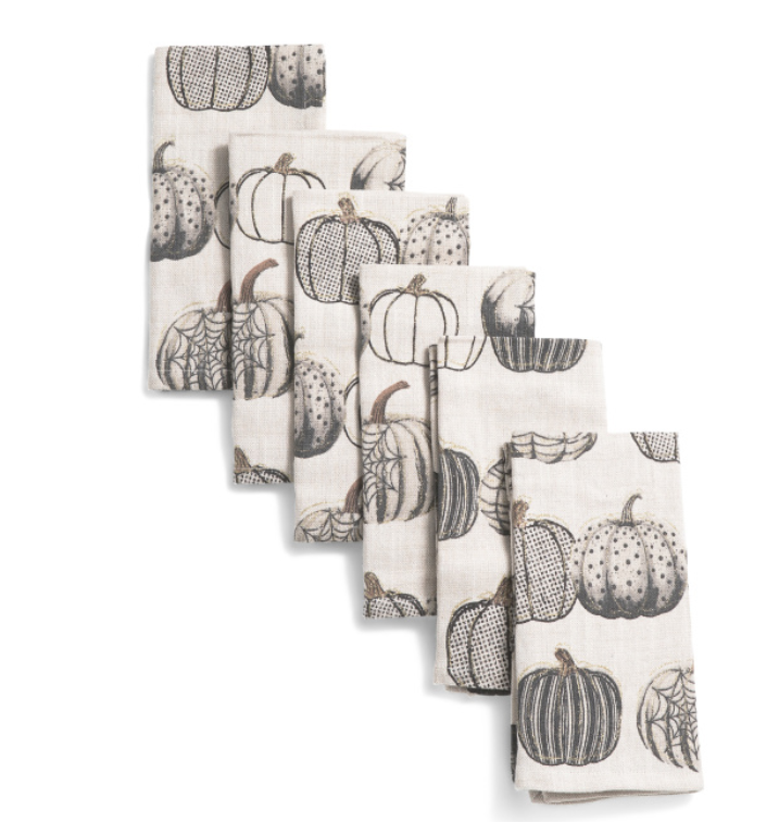 Set of six cotton fall napkins with metallic pumpkin pattern, folded for table display.